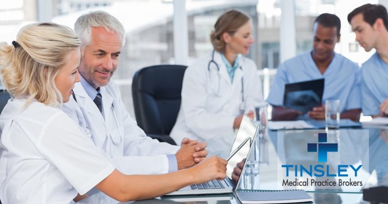 Medical professionals in a meeting with laptops and digital tablets.