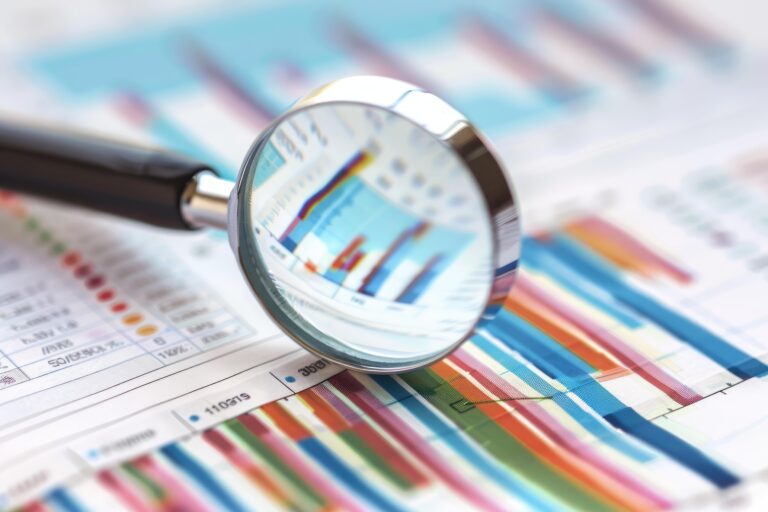 Magnifying glass analyzing financial business charts graphs growth success